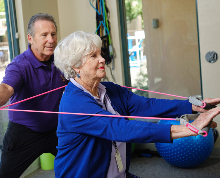 Trainer helping woman exercise