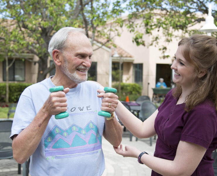 man lifting weights with assistance of employee